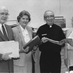 Four people holding archives files.
