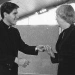 Father Thomas Oddo hands Martha Wachsmuth her fifteen year service pin.