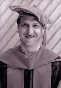 Doctor Matthew Baasten wearing academic cap and gown.