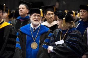 Doctor James Male and Doctor Margaret Hogan and other faculty members in academic regalia.