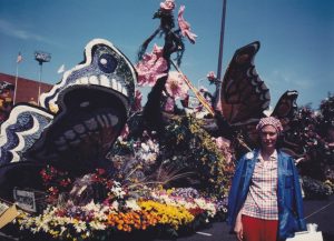 Person standing next to a parade float.