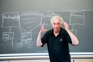 Doctor Peter Thacker in front of a chalkboard and teaching a class.