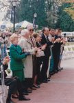People standing at the front row of chairs at a dedication ceremony.