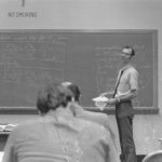 Doctor Robert Albright standing in front of a chalkboard with mathematical equations.