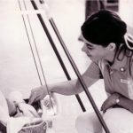 Student nurse Frances Simmons looking at a baby in a carrier.