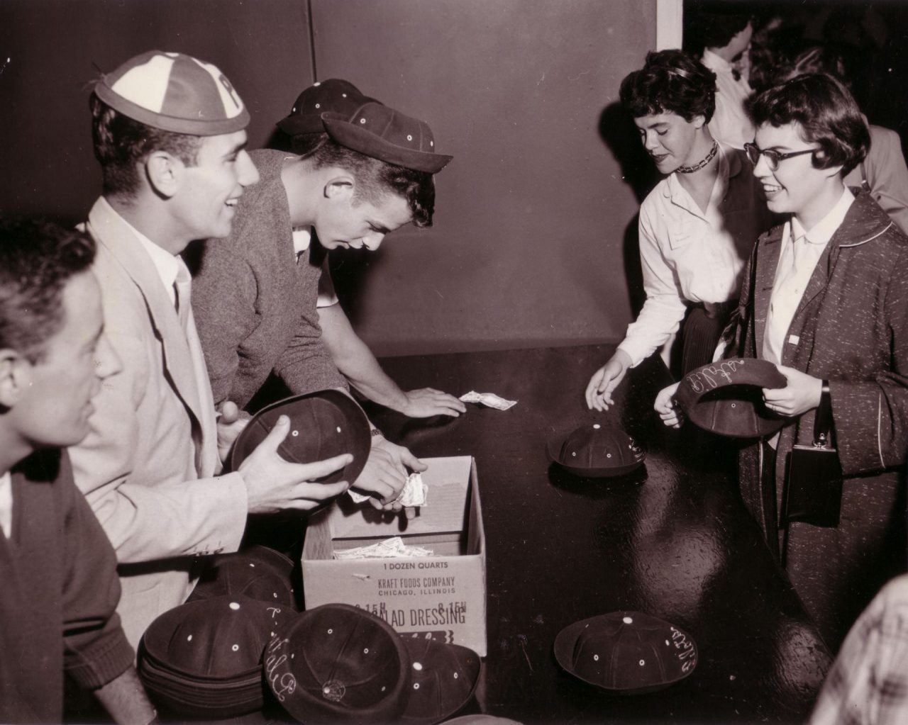 black and white photo of freshman students buying beanie caps