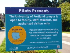 sign posted at entrance to campus with limited access and mask requirement information