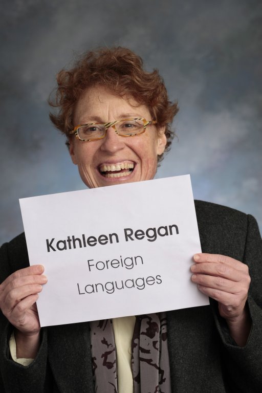 Doctor Kate Regan holding sign with words Kathleen Regan Foreign Languages
