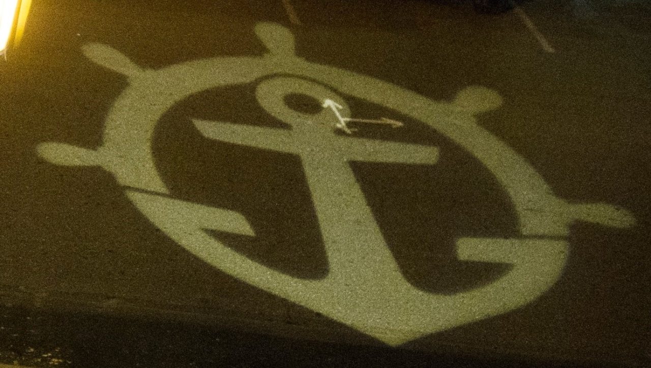 Projected image of the Pilot Wheel and Anchor logo.