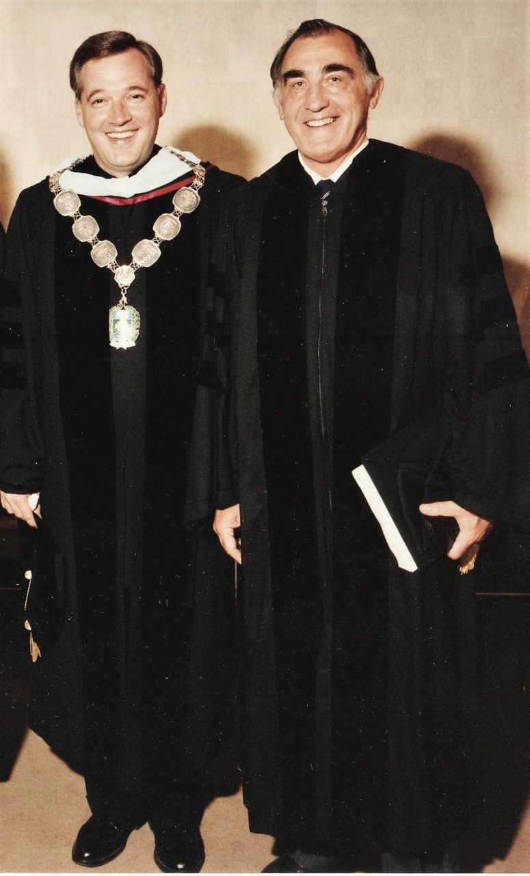 Father David Tyson and Eugene Feltz, both wearing academic regalia.