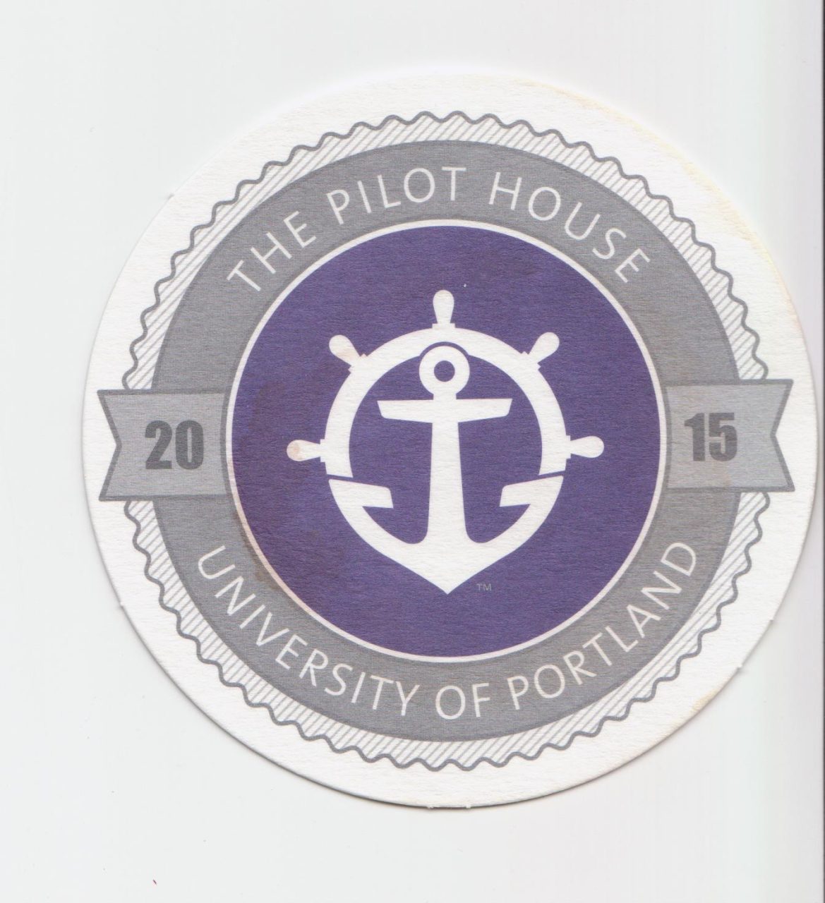 Pilot House Wheel and Anchor logo on beverage coaster.
