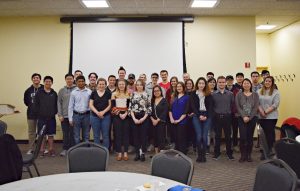 A group photo of students, faculty, and alumni at the Helping Hands event