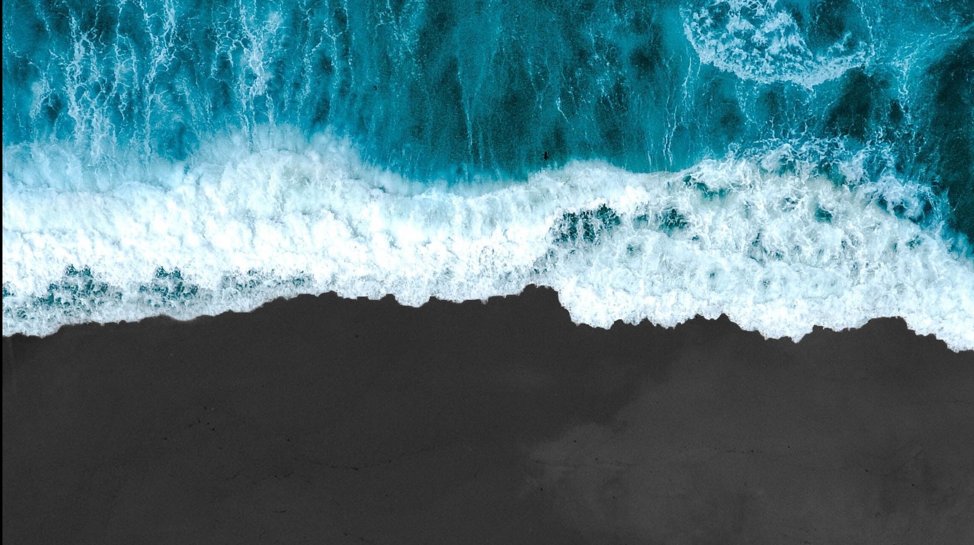 the ocean and the beach from an overhead perspective