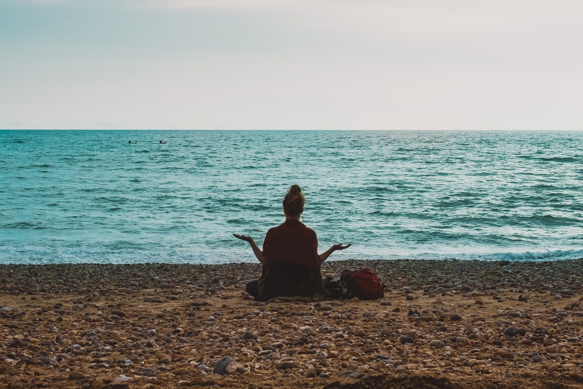 person meditating on a beach